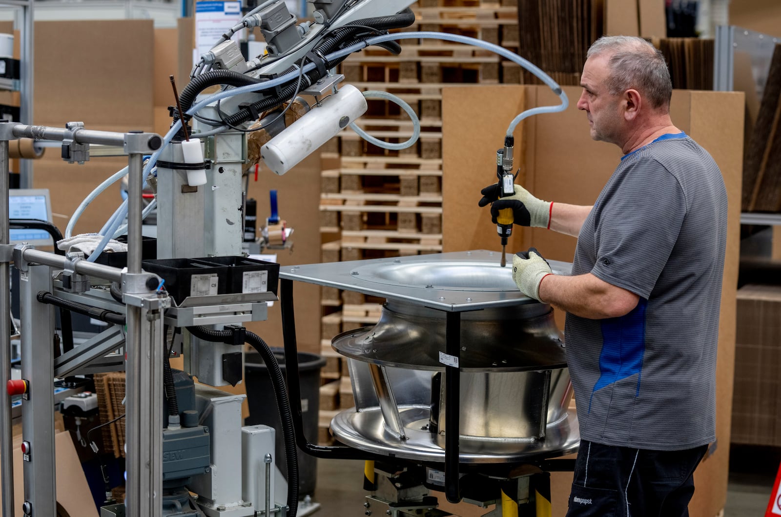 A man works on a fan at an EBM-Papst plant in Hollenbach, Germany, Tuesday, Feb. 4, 2025. (AP Photo/Michael Probst)