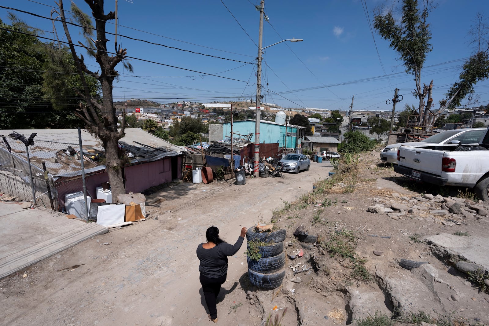 Martha Rosales walks back to her home where she houses Cuban migrants as they wait for an appointment to apply for asylum in the United States through the CBP One app Wednesday, May 22, 2024, in Tijuana, Mexico. (AP Photo/Gregory Bull)