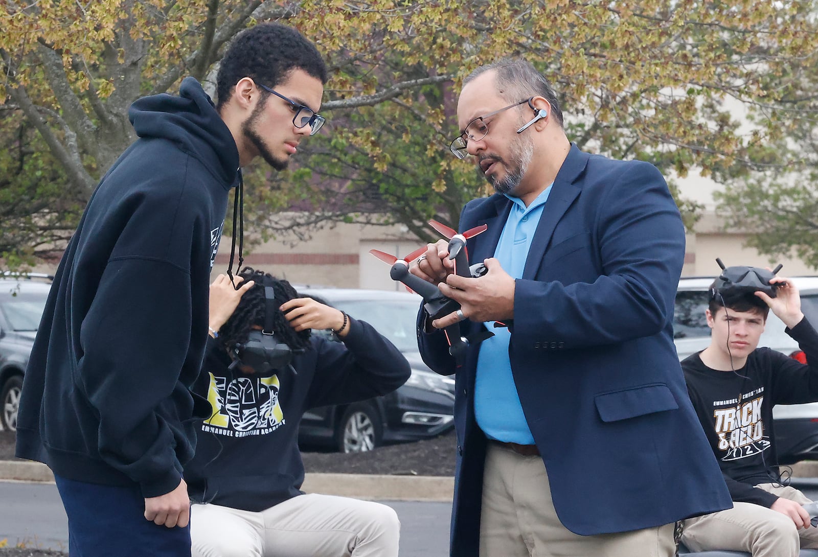 Shadh Molla, professor of Emmanuel Christian Academy Aerospace Institute, explains something about a drone with student Xavier Fudge Tuesday, April 23, 2024 outside the school. BILL LACKEY/STAFF