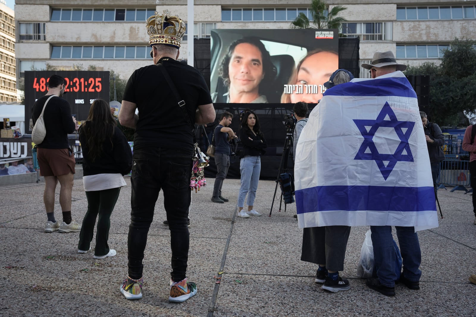 Israelis watch a broadcast of the release of Israelis Ofer Kalderon, 53, and Yarden Bibas, 34, and American-Israeli Keith Siegel, 65 set to be released as part of a ceasefire in the Gaza Strip, in Tel Aviv, Israel, Saturday Feb. 1, 2025. (AP Photo/Oded Balilty3