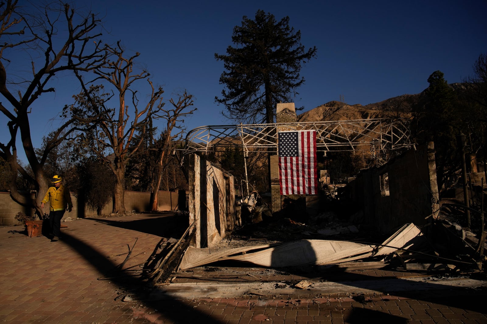 A firefighter inspect homes destroyed by the Eaton Fire in in Altadena, Calif., is seen Wednesday, Jan 15, 2025. (AP Photo/John Locher)