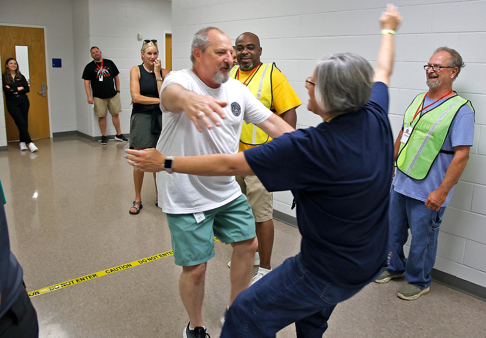 Clark County EMA Deputy Director David Perks, playing the part of a parent, hugs Jennifer Ulery-Smith, playing the part of his daughter and a student, as they're reunited during a reunification training session at Springfield High School Wednesday, June 5, 2024. Most of the Clark County schools along with law enforcement and fire personel participated in the two day training to learn how to get students back with their parents after an emergency situation. 