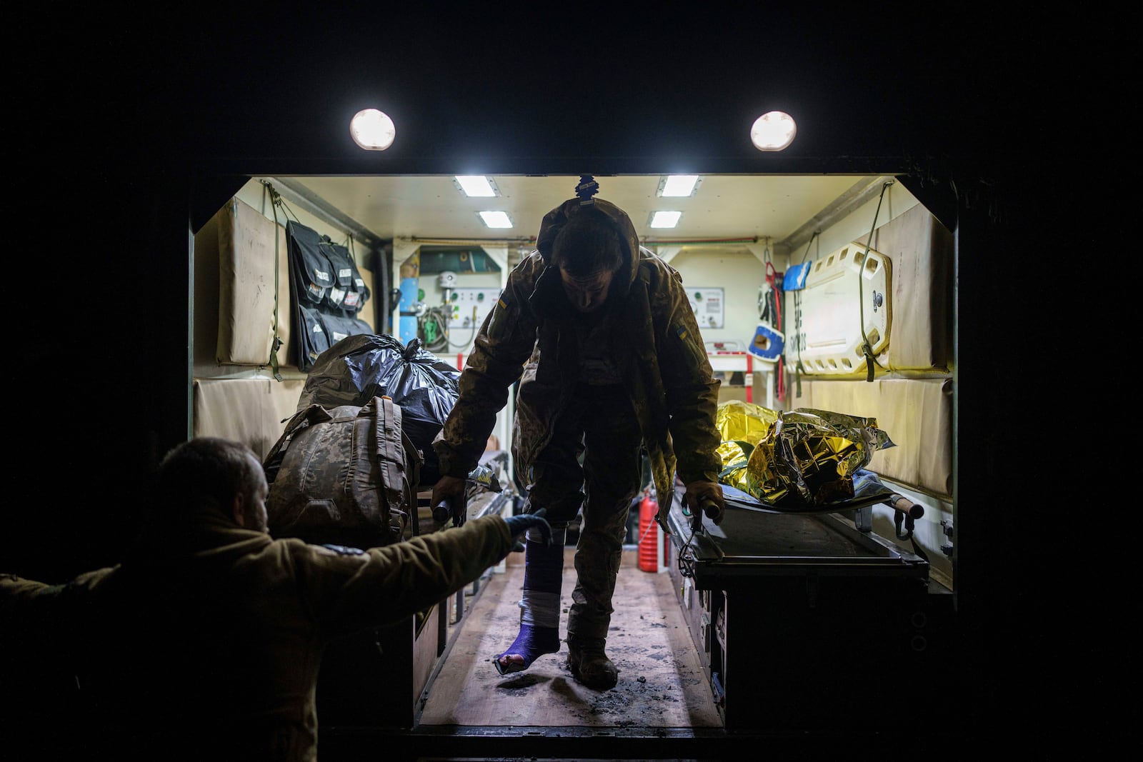 An injured Ukrainian serviceman walks out of an ambulance at Medical Service "Ulf" of the 108th Separate Battalion "Da Vinci Wolves" on Pokrovsk direction, Ukraine, Tuesday, Dec. 24, 2024. (AP Photo/Evgeniy Maloletka)