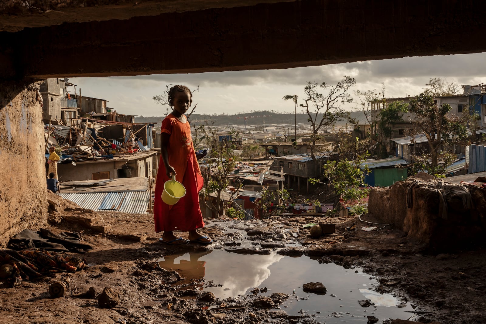 A young girl walks in the Kaweni slum on the outskirts of Mamoudzou, in the French Indian Ocean island of Mayotte, Thursday, Dec. 19, 2024, after Cyclone Chido. (AP Photo/Adrienne Surprenant)