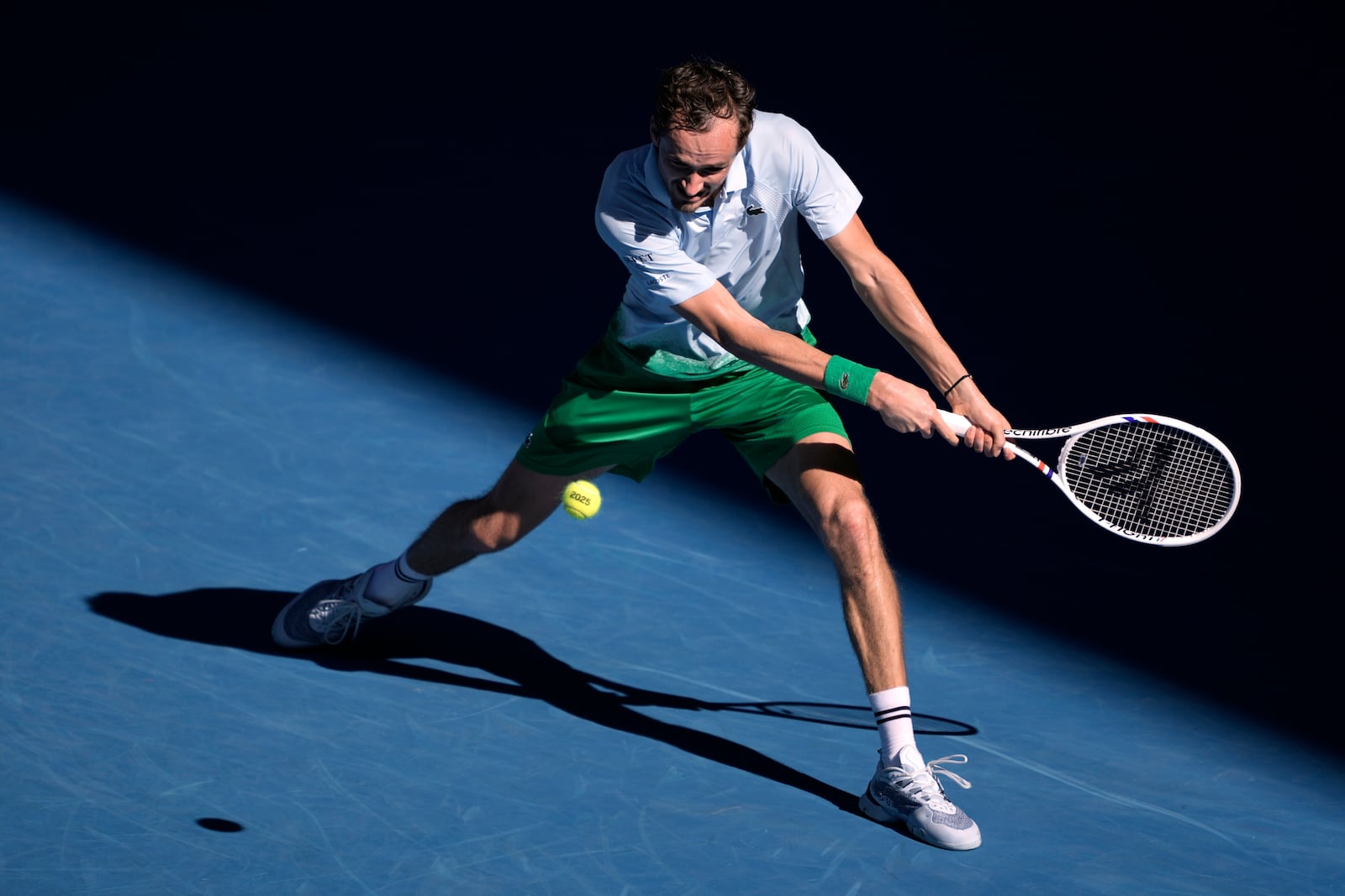 Daniil Medvedev of Russia plays a backhand return to Kasidit Samrej of Thailand during their first round match at the Australian Open tennis championship in Melbourne, Australia, Tuesday, Jan. 14, 2025. (AP Photo/Ng Han Guan)