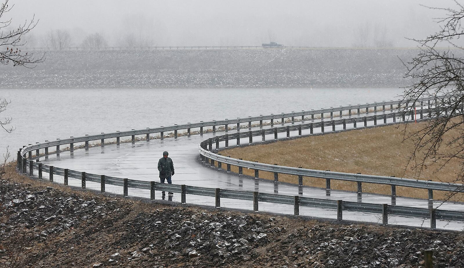 A walker gets in some exercise on the dam at C.J. Brown Reservoir Monday, Jan. 30, 2023 despite miserable conditions. BILL LACKEY/STAFF