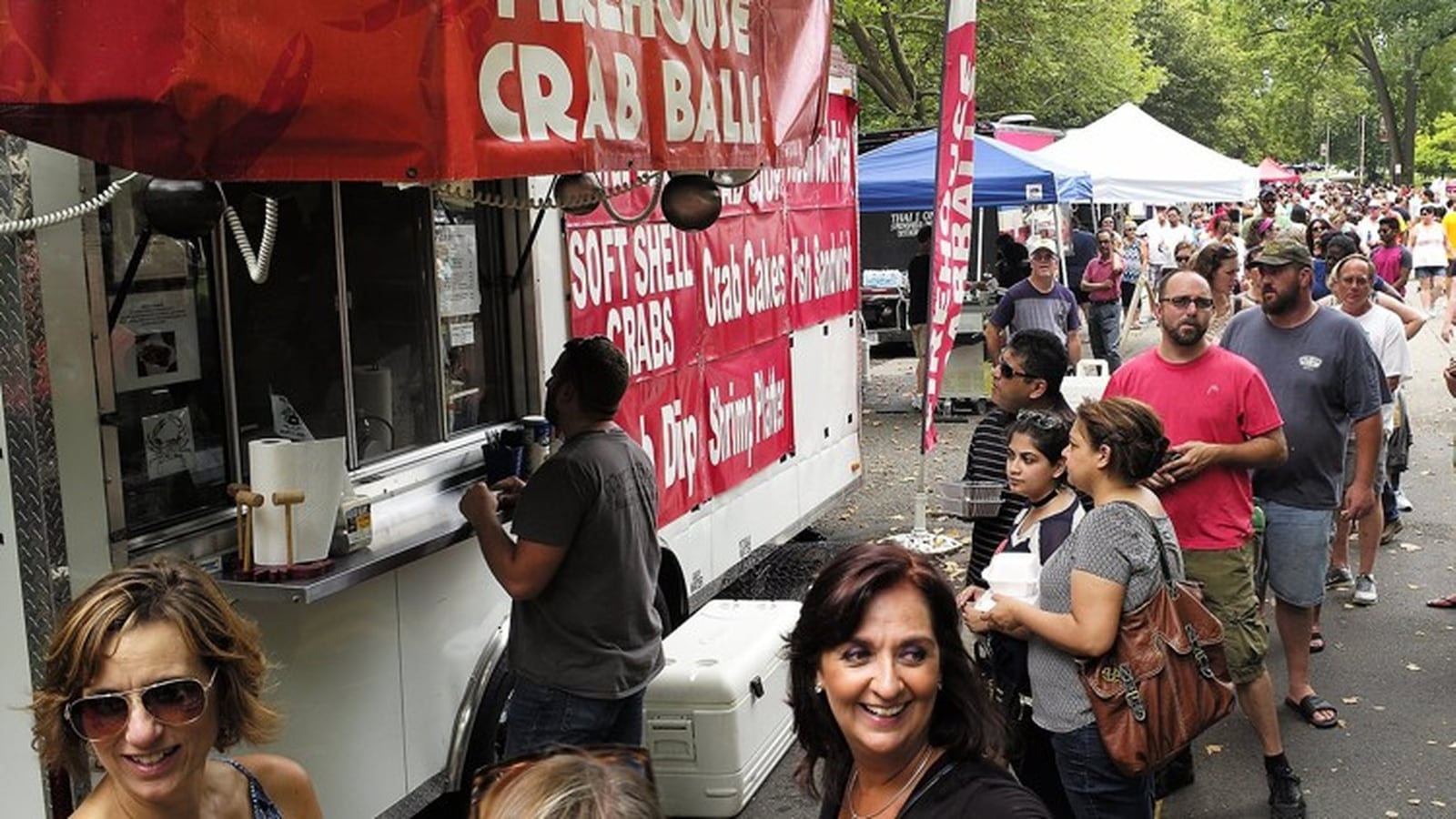 People wait in line to sample some of the Firehouse Crab Balls at the 2016 Springfield Rotary Gourmet Food Truck Competition in Veterans Park. BILL LACKEY/STAFF