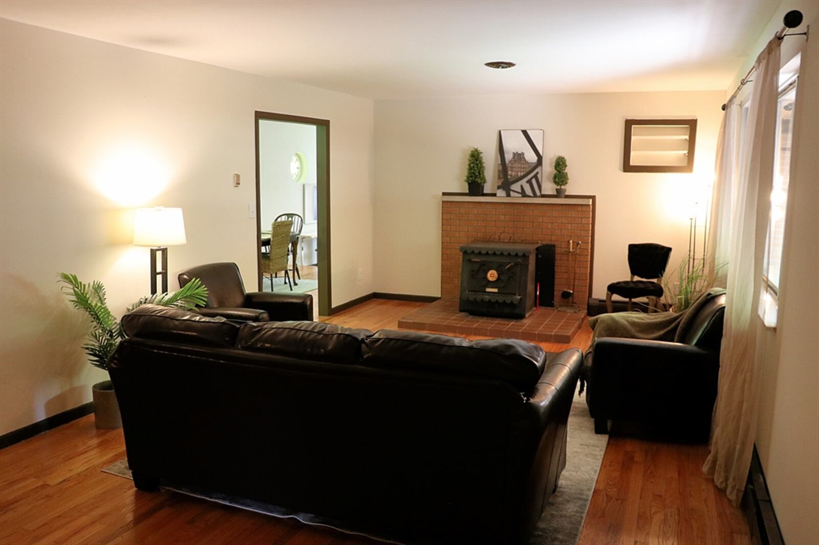 The living room has a wood-burning stove that sits on top of a terra-cotta tile hearth. 