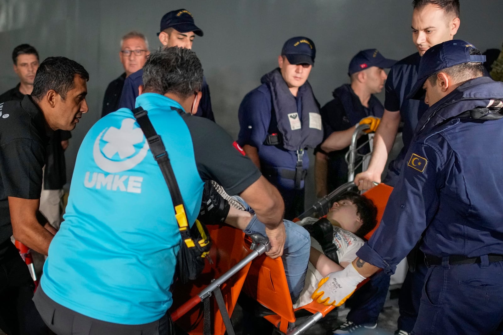 Emergency teams and military personnel help people mostly Turkish nationals to disembark from a Turkish TCG Sancaktar military ship after being evacuated from Lebanon's capital Beirut to Turkey, in Mersin port, southern Turkey, early Friday, Oct. 11, 2024. (AP Photo/Emrah Gurel)