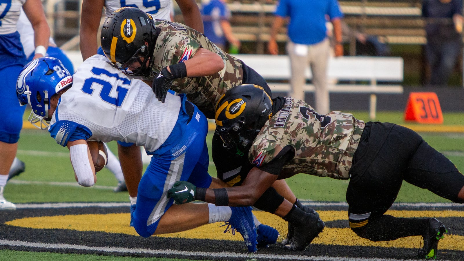 Ross Coppock tackles Miamisburg's Hunter Derr with help from teammate Reggie Powers during a home game earlier this season. Jeff Gilbert/CONTRIBUTED