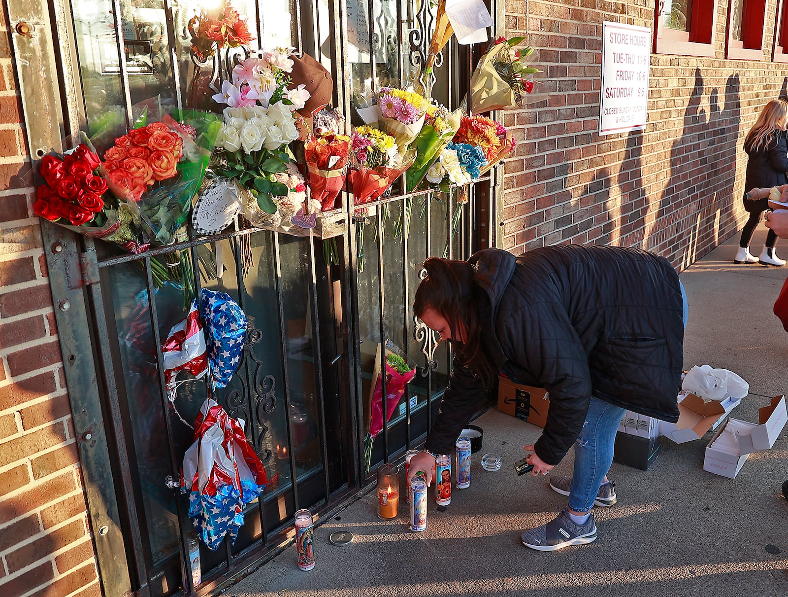 Family, friends and community members fill the parking lot of Gill's Quality Meat Market Monday, Jan. 9, 2023 during a candle light vigil for Thomas Gill, who was shot and killed last Thursday while driving his SUV in Springfield. BILL LACKEY/STAFF