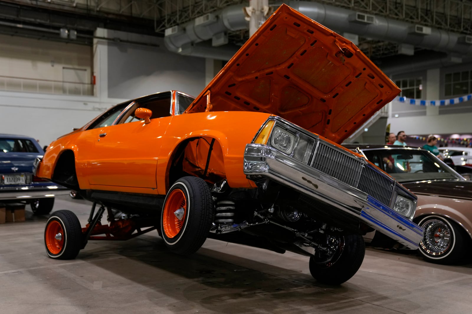 An orange lowrider car is on display at the Slow & Low Chicago Lowrider Festival, Saturday, Oct. 12, 2024, at Navy Pier in Chicago. (AP Photo/Erin Hooley)