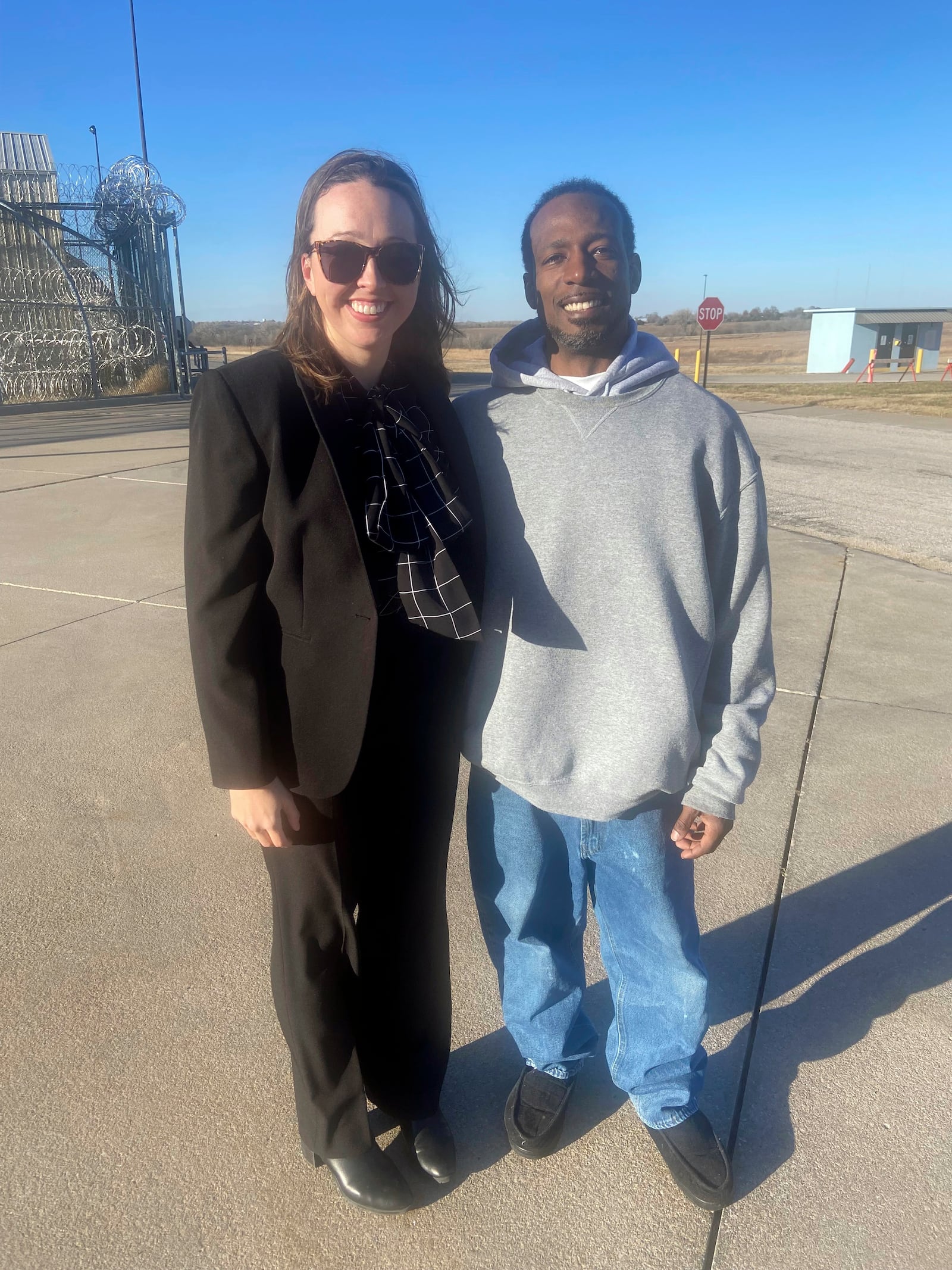 In this photo provided by Bob Hoffman, Dominique Moore, 40, poses with one of his attorneys, Courtney Stout, after he was released from prison when a judge overturned his conviction in a double homicide case, Wednesday, Dec. 11, 2024, in El Dorado, Kan. (Bob Hoffman via AP)