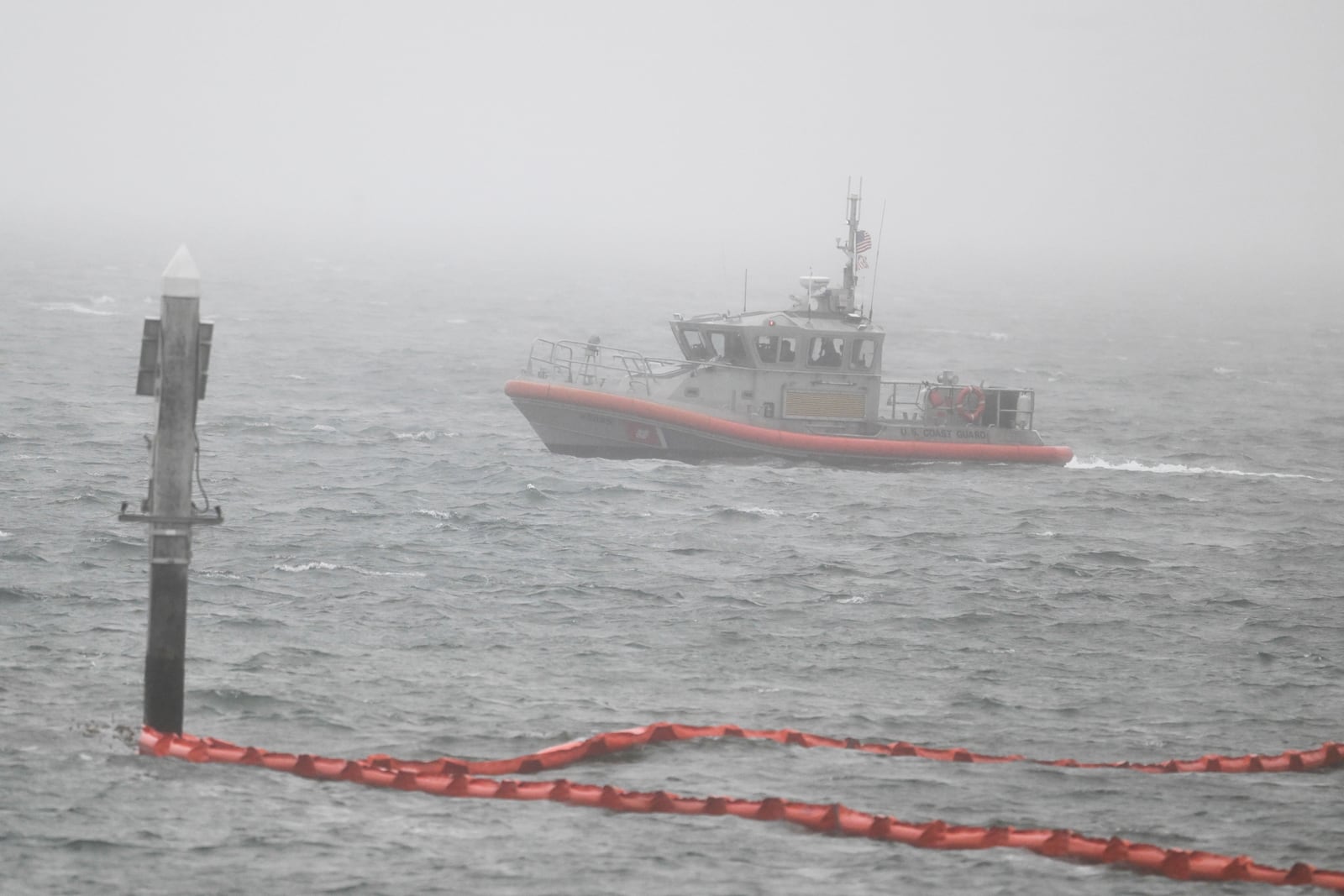 A U.S. Coast Guard boat works along the shore near Shelter Island after a U.S. Navy plane crashed into the San Diego Bay, Wednesday, Feb. 12, 2025, in San Diego. (AP Photo/Denis Poroy)