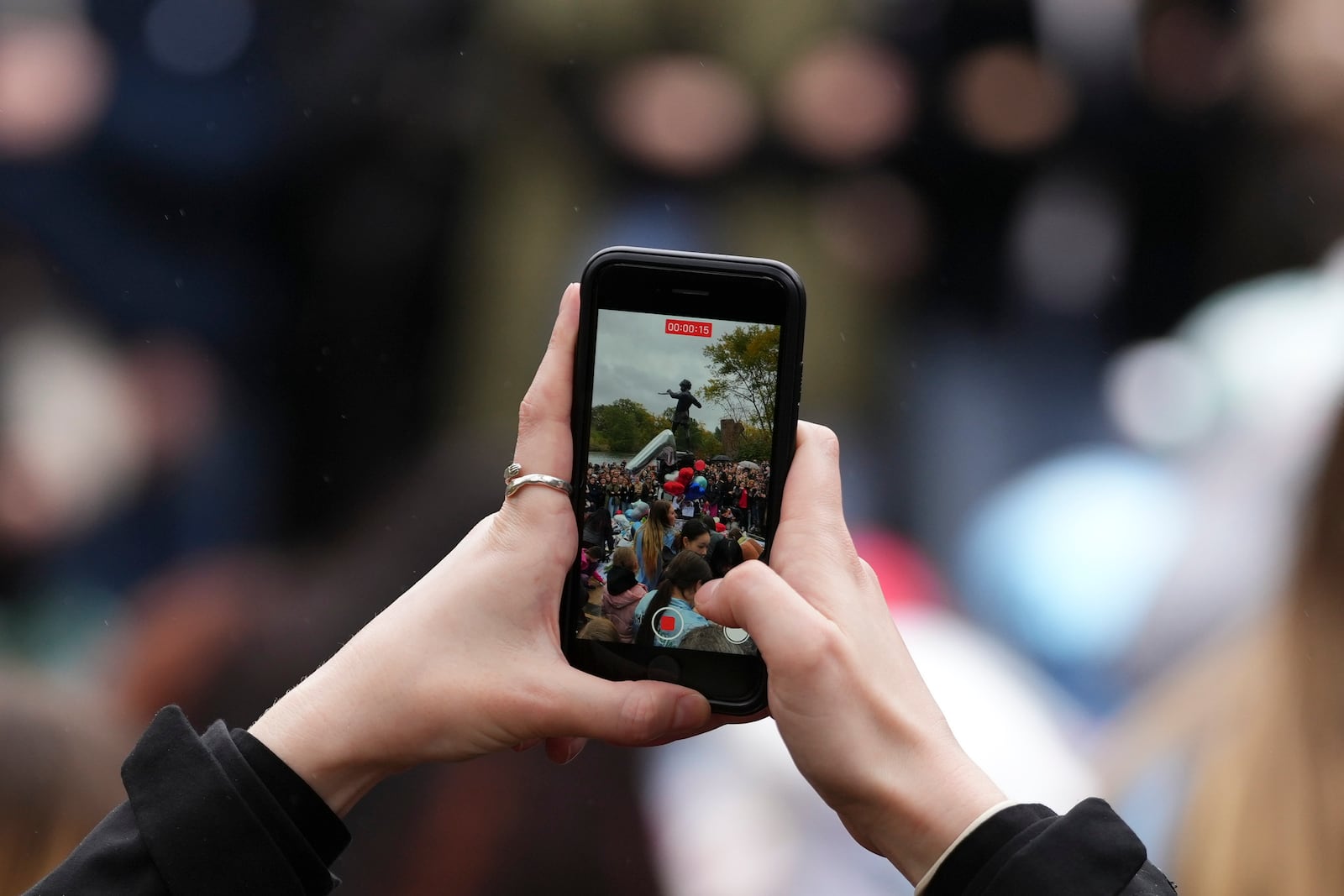 A fan takes a photo near the Peter Pan statue in Hyde Park, London where people gathered to pay tribute to late British singer Liam Payne, former member of the British pop band One Direction, Sunday, Oct. 20, 2024. (Photo by Scott A Garfitt/Invision/AP)