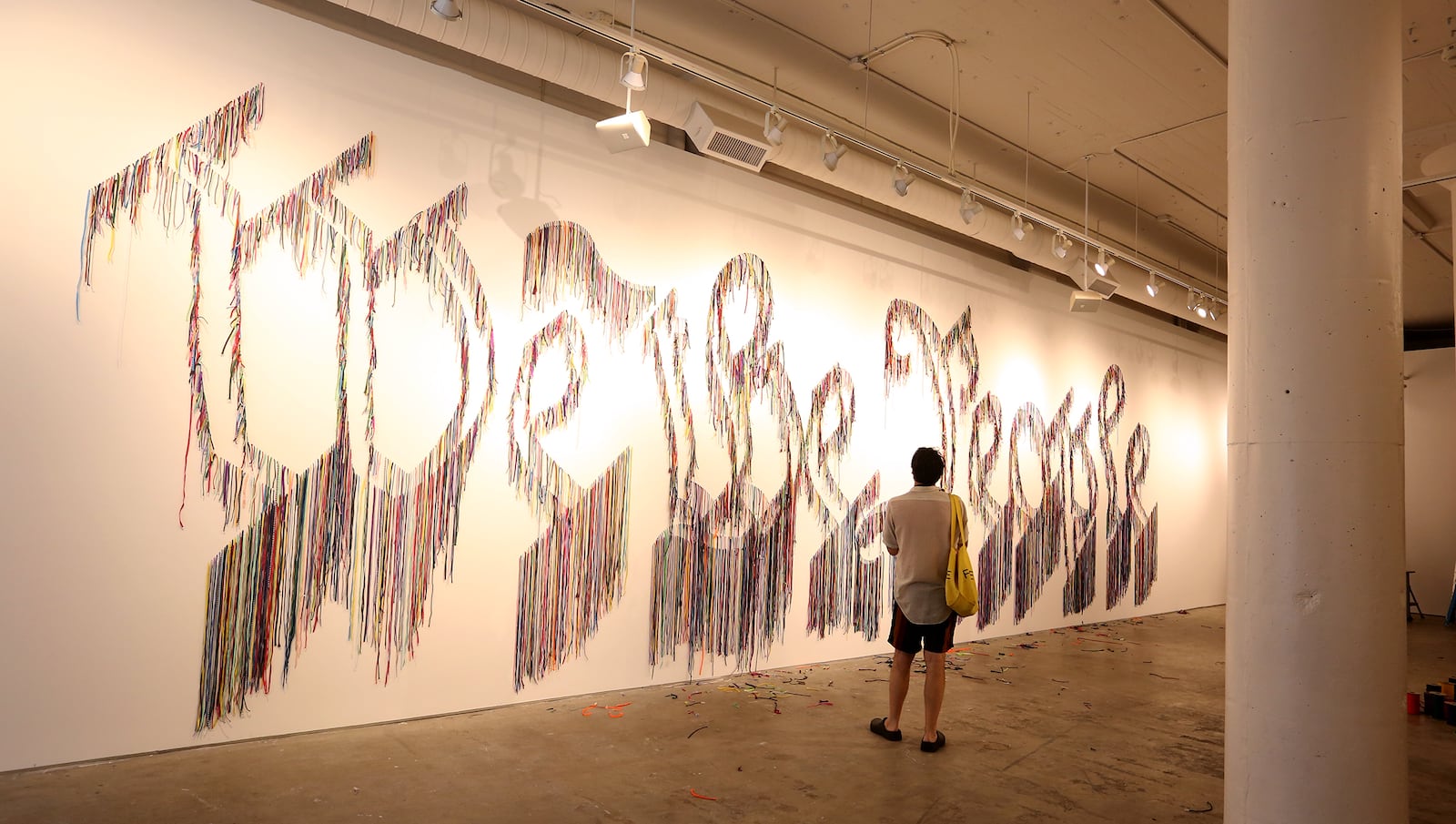 Volunteers hang thousands of shoelaces at The Contemporary Dayton Wednesday to create We The People, a 50-foot-wide wall installation designed by artist Nari Ward. The installation pairs humble of materials (shoelaces) with one of the country’s most lofty and enduring ideas—the U.S. Constitution, according to a release. The artwork will be on display through Nov. 30. The Co has also partnered with the League of Women Voters of the Greater Dayton Area to transform a portion of the gallery into a voter registration center.  LISA POWELL / STAFF