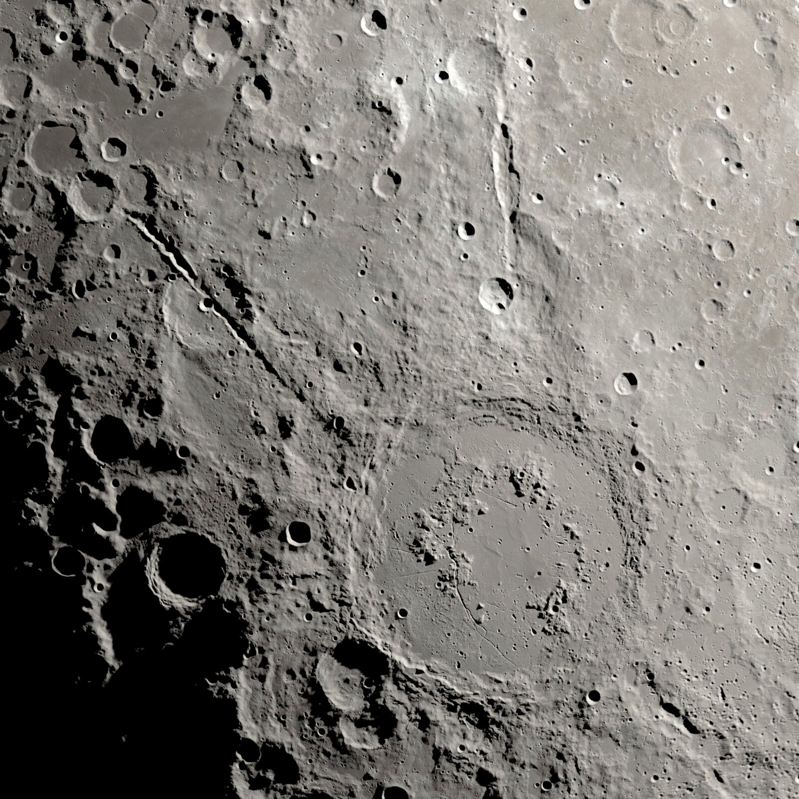 This image provided by NASA shows a view from orbit, looking straight down at the Moon’s surface, where an ancient asteroid strike carved out a pair of grand canyons on the moon’s far side. (Ernie T. Wright/NASA via AP)