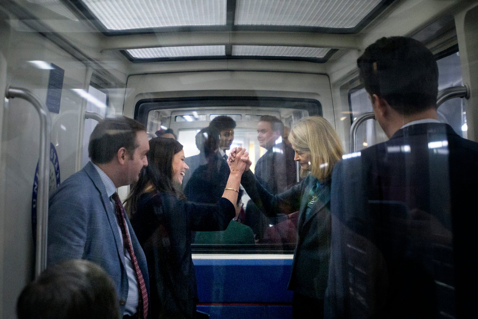 Sen. Lisa Murkowski, R-Alaska, right, shakes hands with Sen. Katie Britt, R-Ala., left, as they ride the Senate subway at the Capitol, Thursday, Jan. 23, 2025, in Washington. (AP Photo/Rod Lamkey, Jr.)