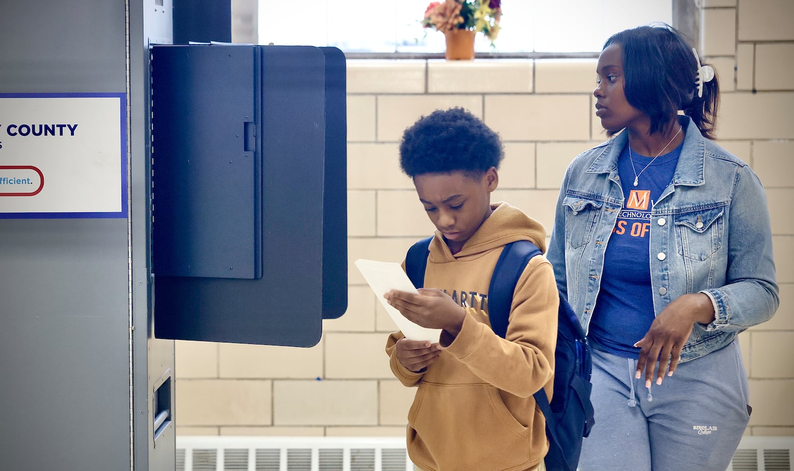 Emilio Jackson, 9, looks over the ballot of his mother, Erionna Johnson, after she voted at the Fairview United Methodist Church on Tuesday, Nov. 5, 2024. MARSHALL GORBY / STAFF