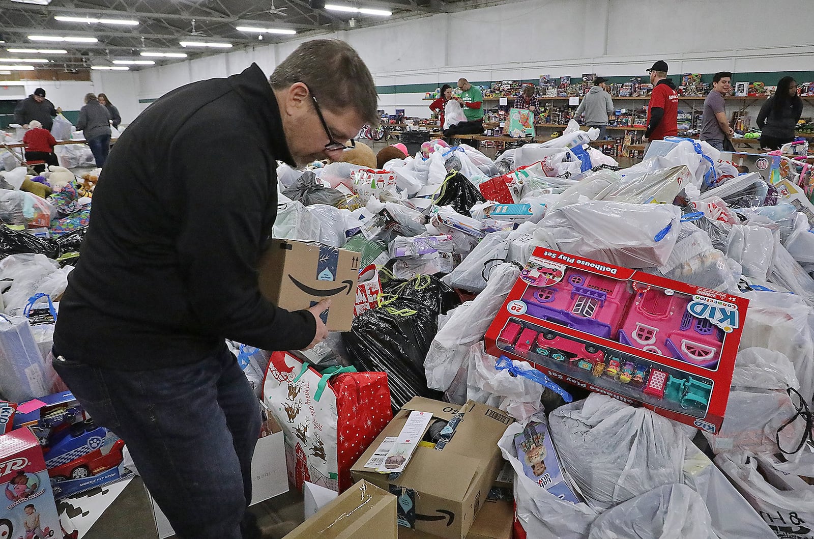 Kevin Kolenda, from Gordon Foods, sorts through the giant pile of toys dropped off by Speedway employees Friday at the Salvation Army’s “Toy Shop.” Speedway is supplying Christmas gifts for over 700 needy kids in the Springfield through the Salvation Army’s Angel Tree program. BILL LACKEY/STAFF