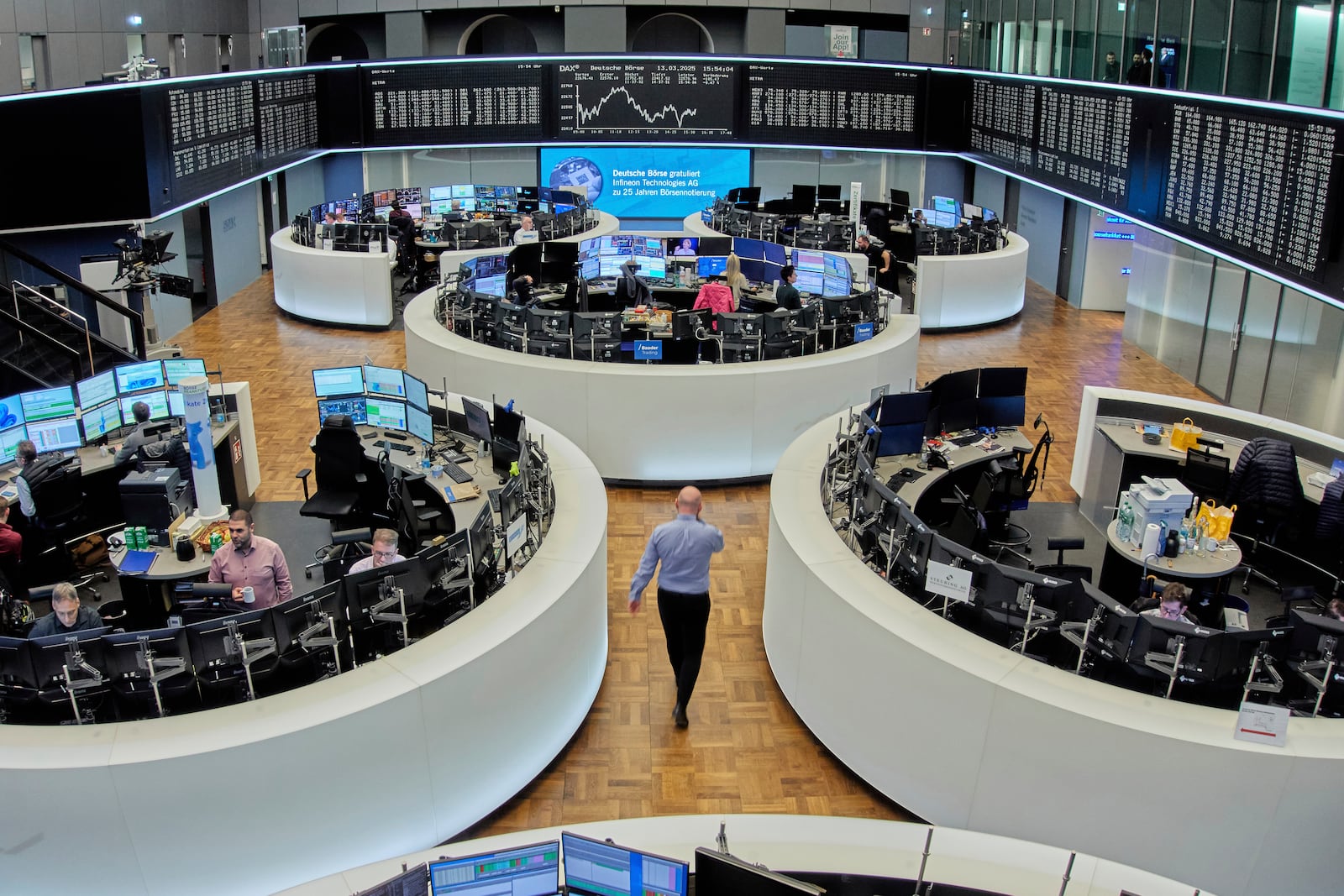 A man walks through the stock market in Frankfurt, Germany, Thursday, March 13, 2025. (AP Photo/Michael Probst)