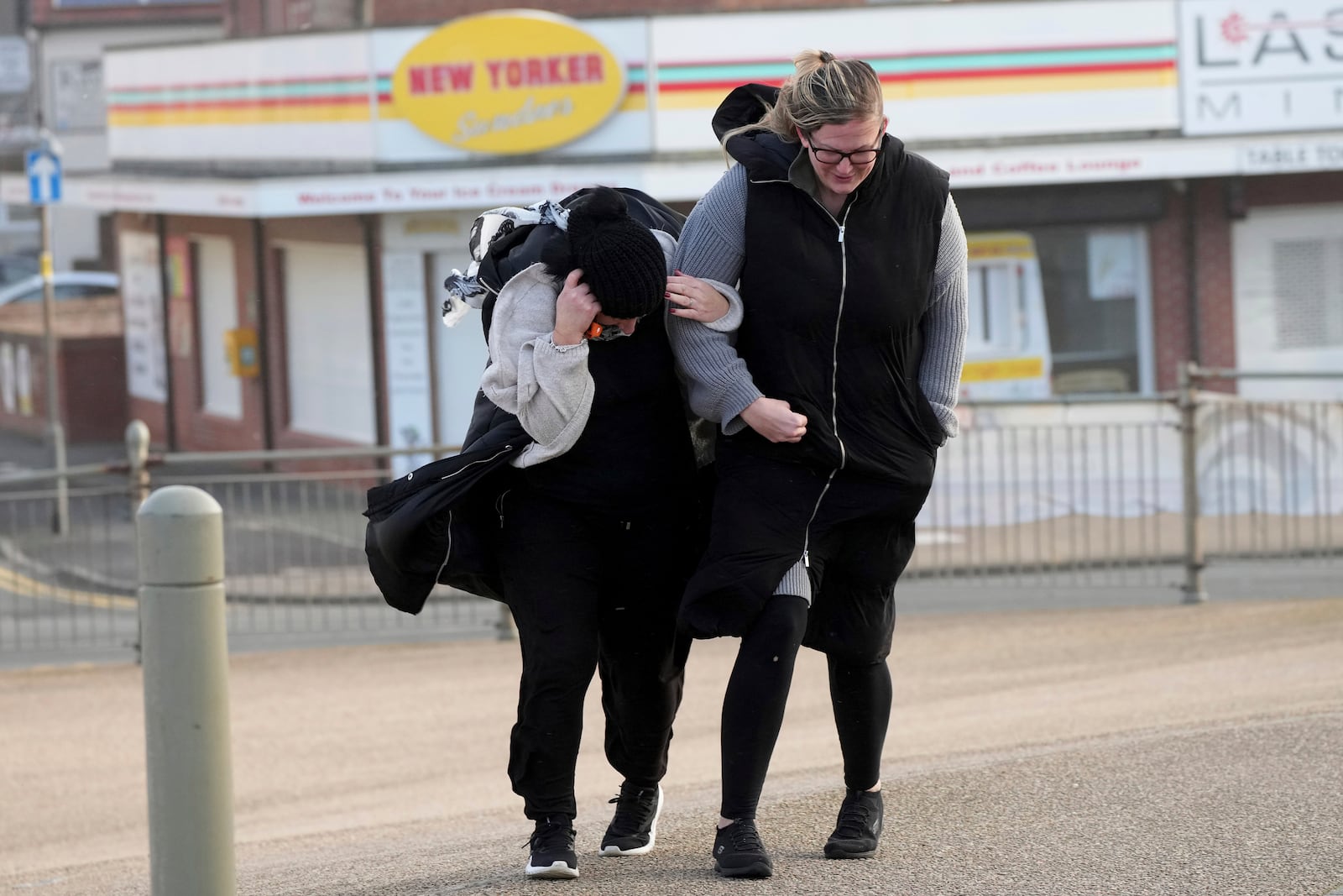 Two women brave the wind as Storm Eowyn hits the country in Cleveleys, near Blackpool, England, Friday, Jan. 24, 2025.(AP Photo/Jon Super)