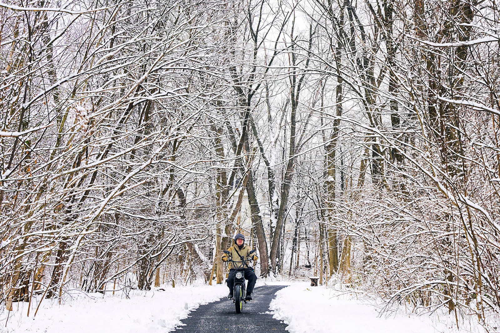 Jose Escobar rides his motorized bicycle on the trails in Rock Creek Park in Frederick, Md. on Wednesday, Feb. 12, 2025, after snowfall overnight. Parts of the area received 2-4 inches of snow. (Ric Dugan/The Frederick News-Post via AP)