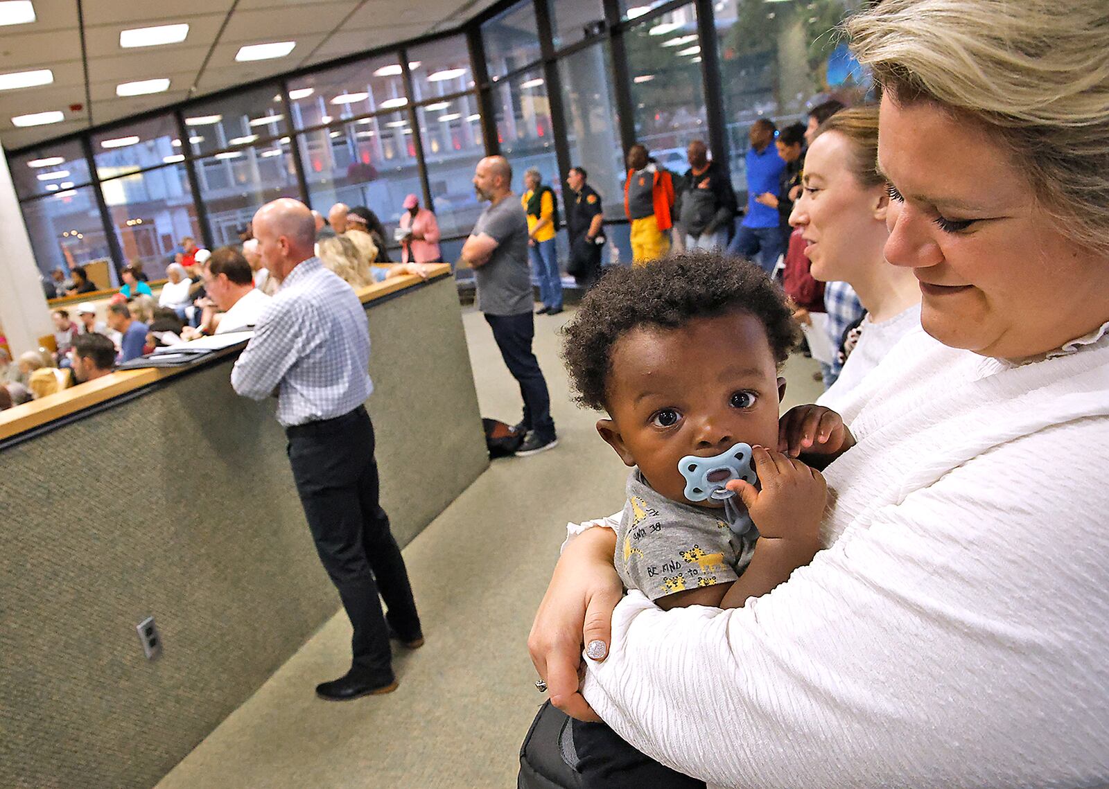 The youngest person at Tuesday night's crowded Springfield City Commission meeting, Kai Young, was more concerned with his pacifier than the immigrant crisis most of the people were there to discuss. Kai was being held by his adopted mother, Carolyn, who works for Mercy Health, in the back of the room while others shouted at each other. BILL LACKEY/STAFF