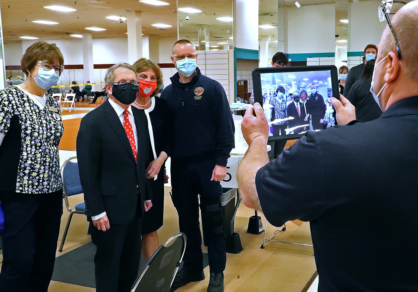 Governor Mike DeWine and his wife, Fran, take a picture with volunteers, including from German Twp. Fire Dept., on a visit to the Clark County vaccine distribution center this month. BILL LACKEY/STAFF