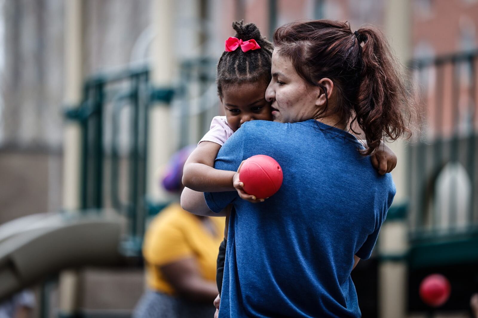 Mini University at Sinclair Community College PreK teacher, Kristen Powderly gives student, Autumn Robinson a hug Wednesday April 5, 2023. JIM NOELKER/STAFF