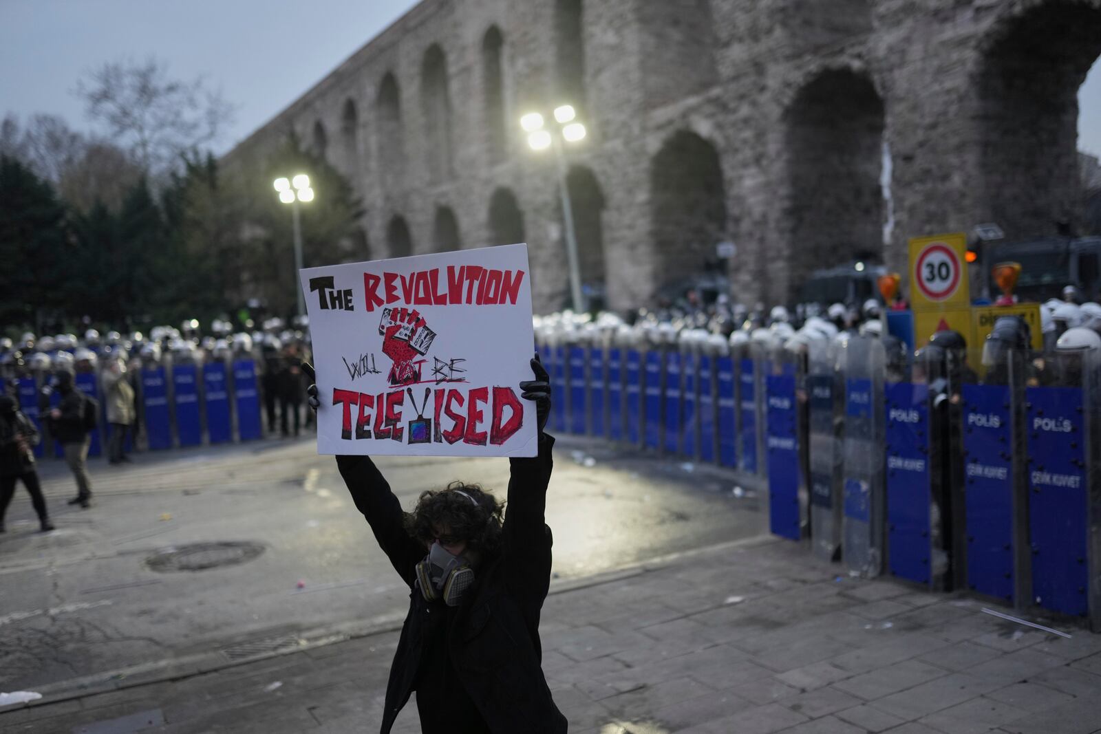 A protester holds up banner during a protest after Istanbul's Mayor Ekrem Imamoglu was arrested and sent to prison, in Istanbul, Turkey, Sunday, March 23, 2025. (AP Photo/Francisco Seco)