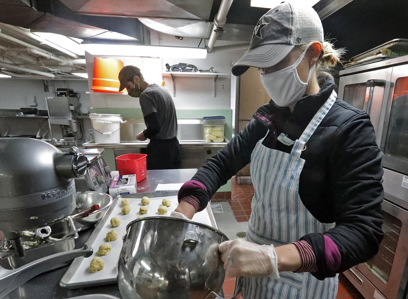 Doug McGregor and Margaret Mattox, owners of Season's Kitchen, work on carryout meals in the shared kitchen in the Bushnell Building last year. BILL LACKEY/STAFF