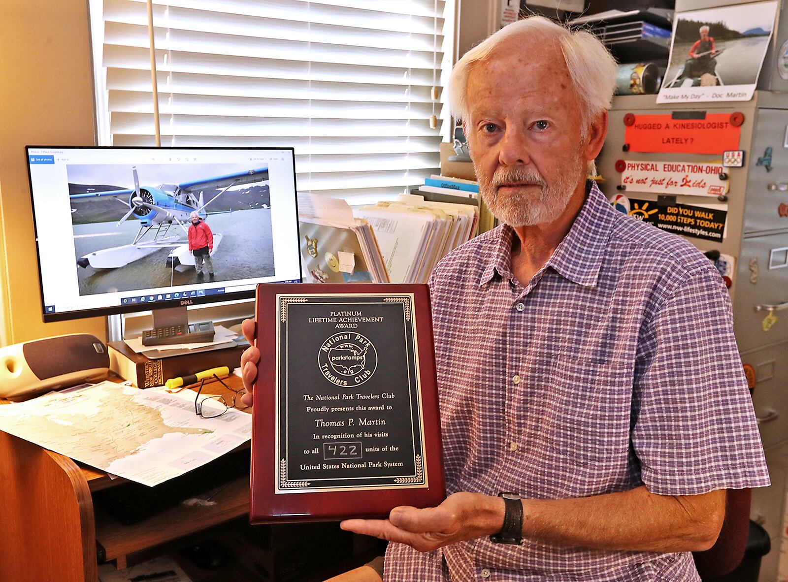 Tom Martin with the Platinum Lifetime Achievement Award he received from the National Park Travelers Club for visiting all 422 units of the United States National Park System. BILL LACKEY/STAFF