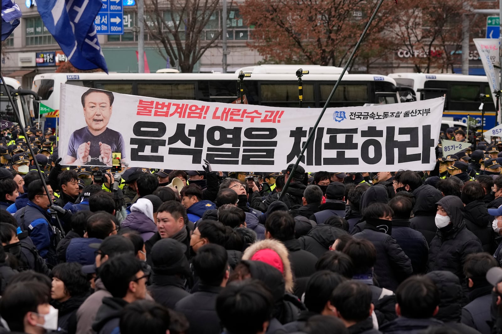 Protesters confront with police officers as they march to the presidential office after a rally demanding South Korean President Yoon Suk Yeol's impeachment in Seoul, South Korea, Thursday, Dec. 12, 2024. The signs read "Arrest Yoon Suk Yeol." (AP Photo/Ahn Young-joon)