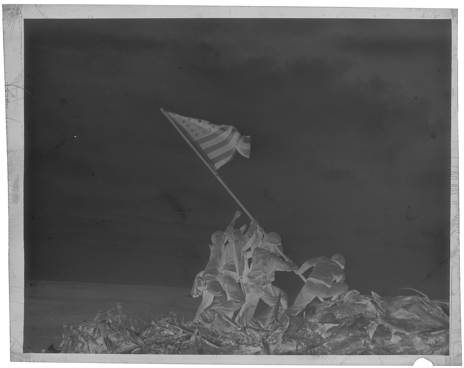 FILE - This is a full frame scan of the 4x5 negative of Joe Rosenthal's iconic Iwo Jima flag-raising photo from Feb. 23, 1945 and seen Oct. 24, 2017 in the Associated Press Photo Library in New York City. (AP Photo, File)