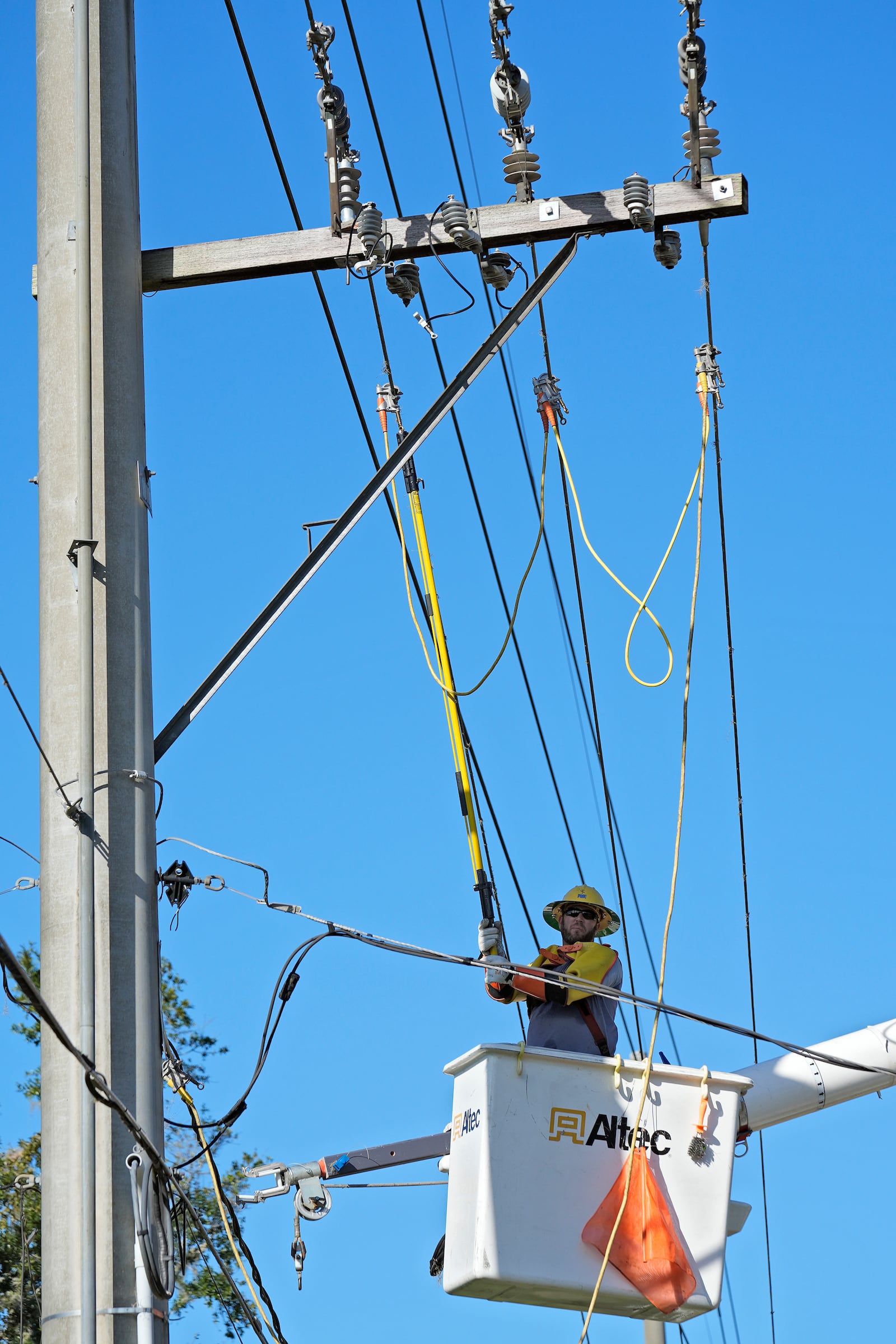 A lineman from Pike Corporation, of North Carolina, works on electrical wires damaged by Hurricane Milton, Sunday, Oct. 13, 2024, in Valrico, Fla. (AP Photo/Chris O'Meara)