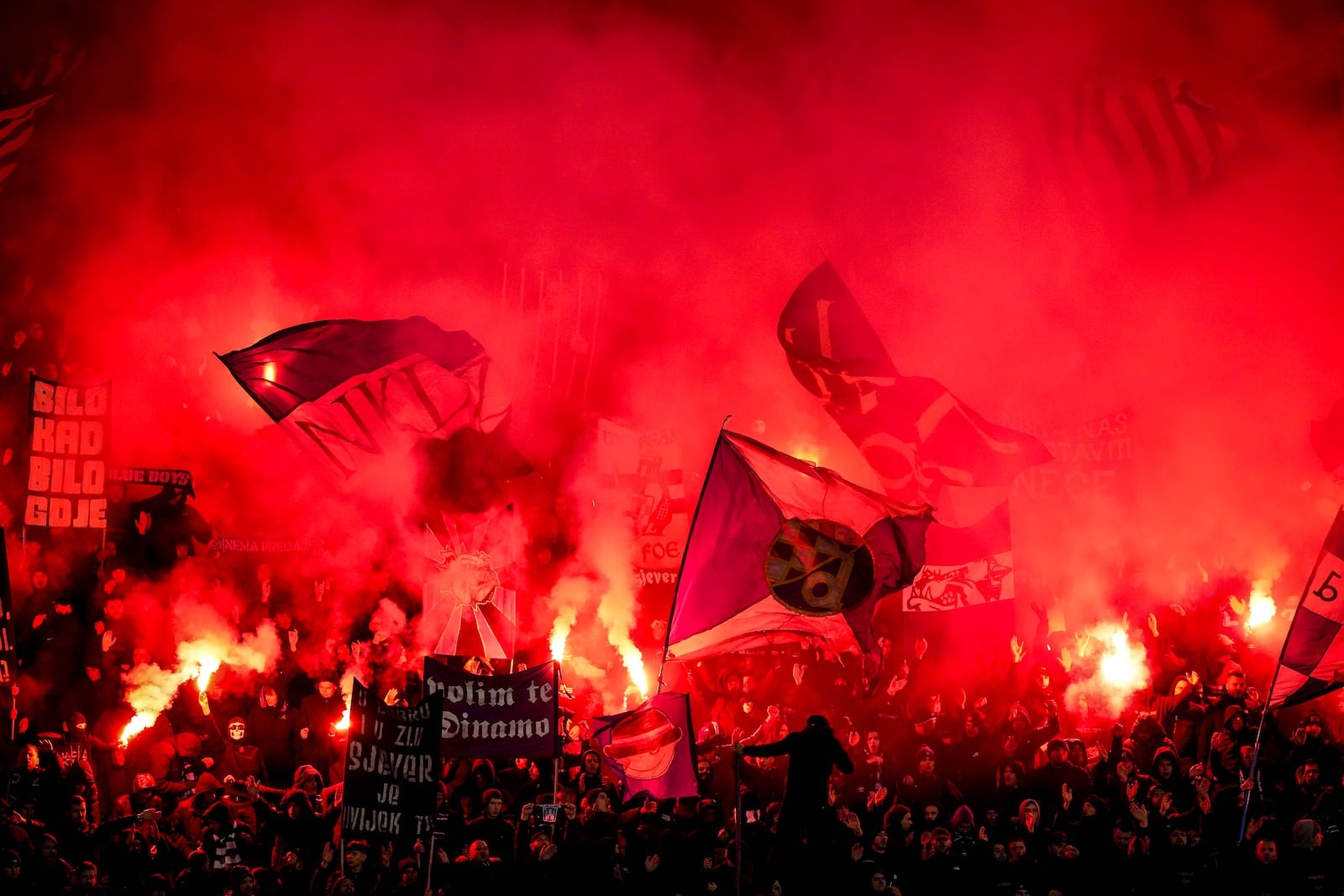 Dinamo fans light flares during the Champions League opening phase soccer match between Dinamo Zagreb and Celtic, at Maksimir stadium in Zagreb, Croatia, Tuesday, Dec. 10, 2024. (AP Photo/Darko Vojinovic)