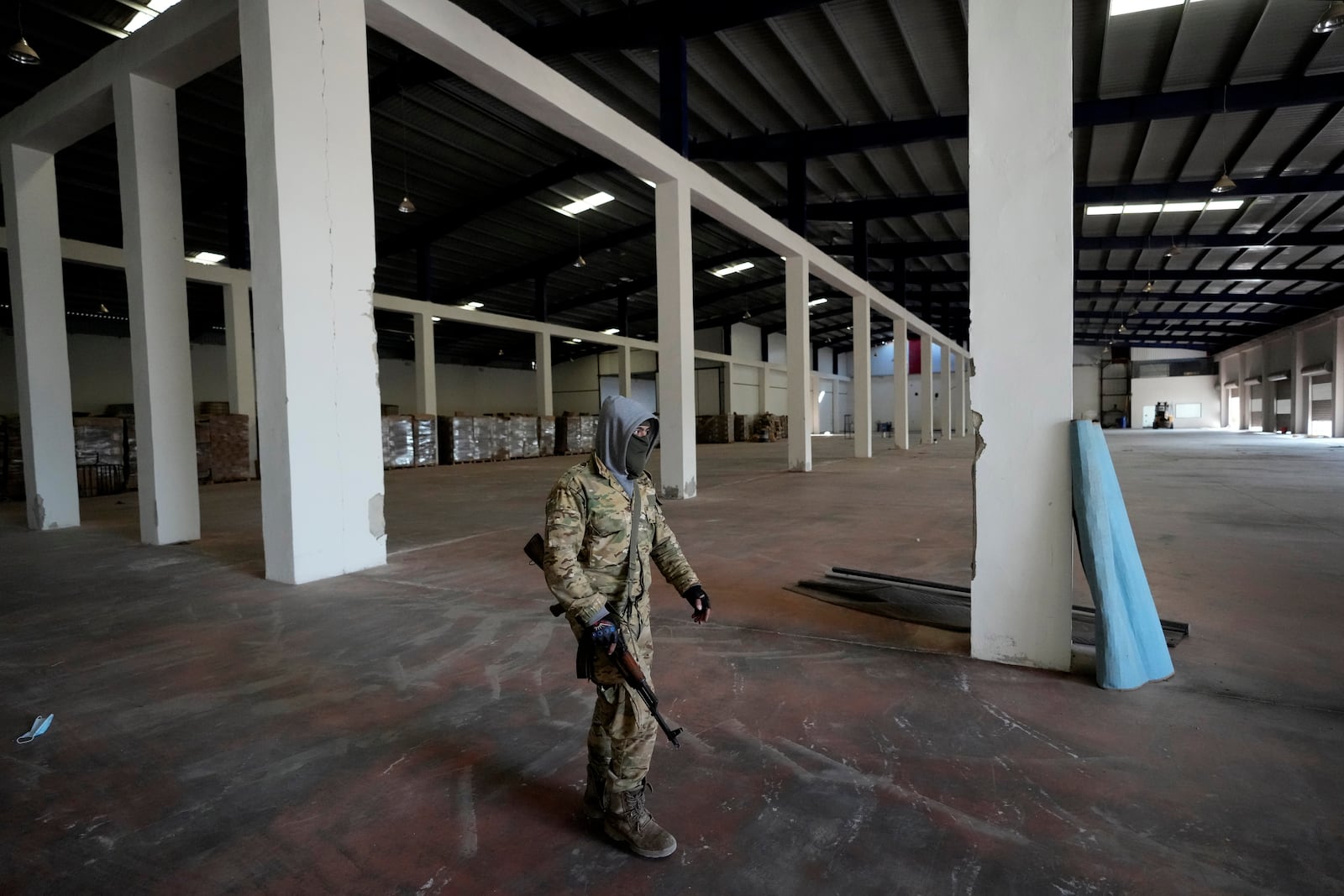 A Syrian member of the rebel group walks at a warehouse where the amphetamine pills known as Captagon were manufactured before the fall of Bashar Assad government in Douma city, outskirts of Damascus, Syria, Friday, Dec. 13, 2024. (AP Photo/Hussein Malla)