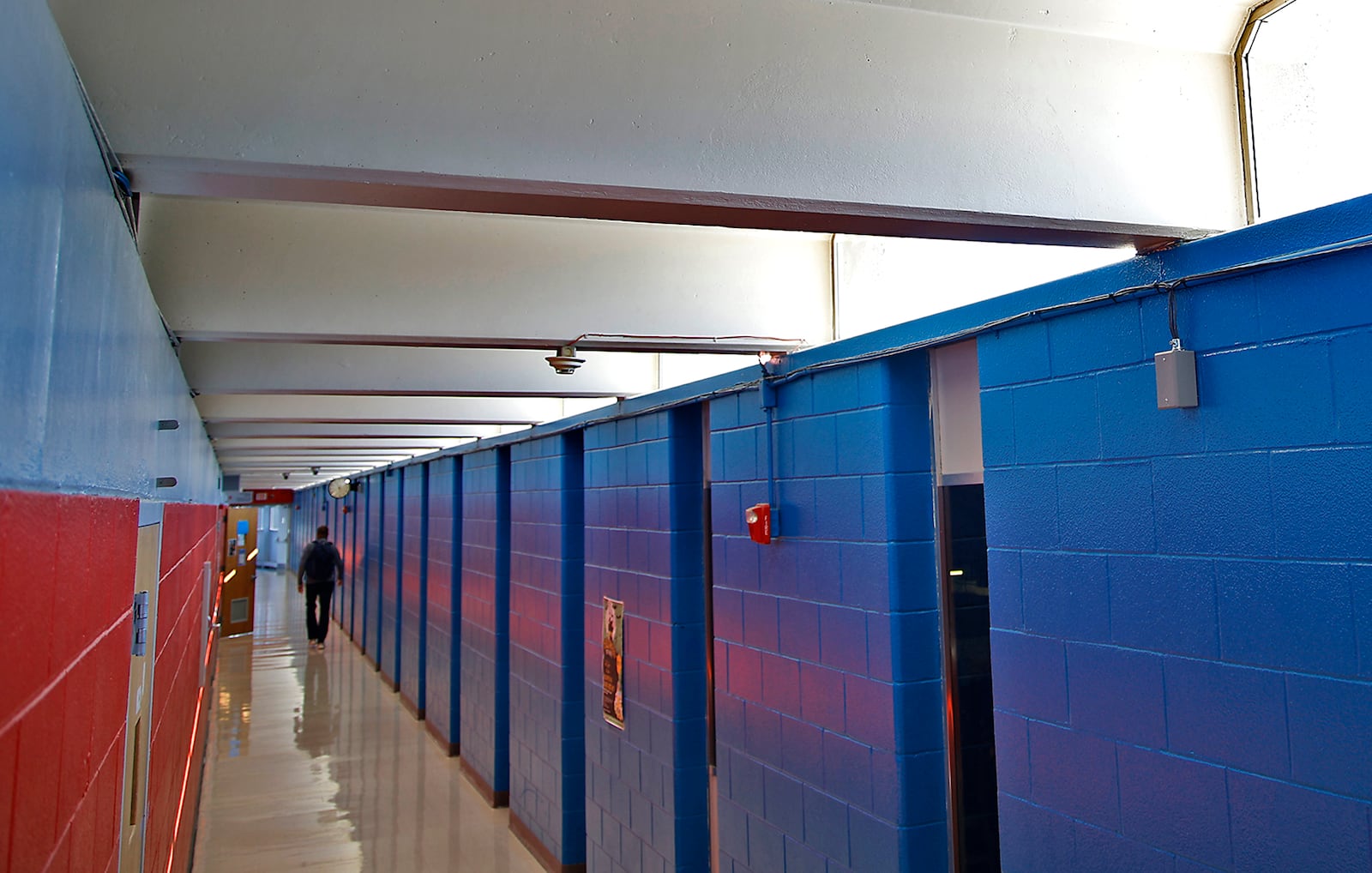 A Springfield-Clark Career Technology Center student walks down a narrow hallway in the school Oct. 12, 2023. The concrete beams that make up roof of the building allow water to enter the building through windows near the ceiling. BILL LACKEY/STAFF