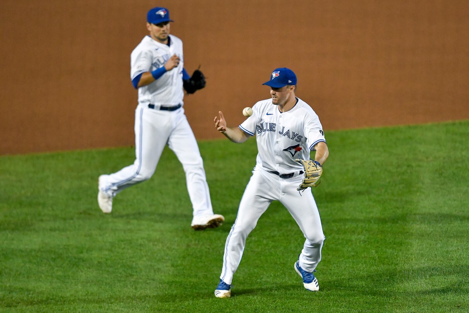 Toronto Blue Jays pitcher Ross Stripling, right, bobbles a grounder hit by New York Yankees' Clint Frazier during the seventh inning of a baseball game in Buffalo, N.Y., Wednesday, Sept. 9, 2020. Frazier was safe at first. (AP Photo/Adrian Kraus)