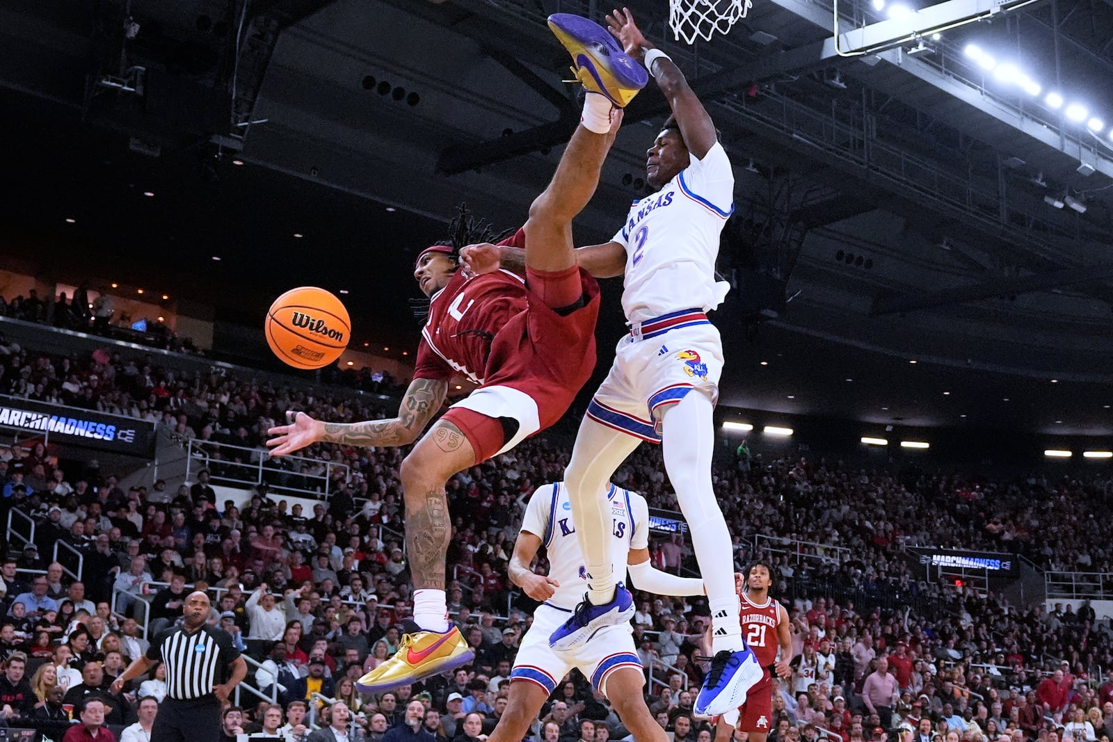 Arkansas guard Boogie Fland, left, is fouled by Kansas guard AJ Storr, right, during the first half in the first round of the NCAA college basketball tournament, Thursday, March 20, 2025, in Providence, R.I. (AP Photo/Charles Krupa)