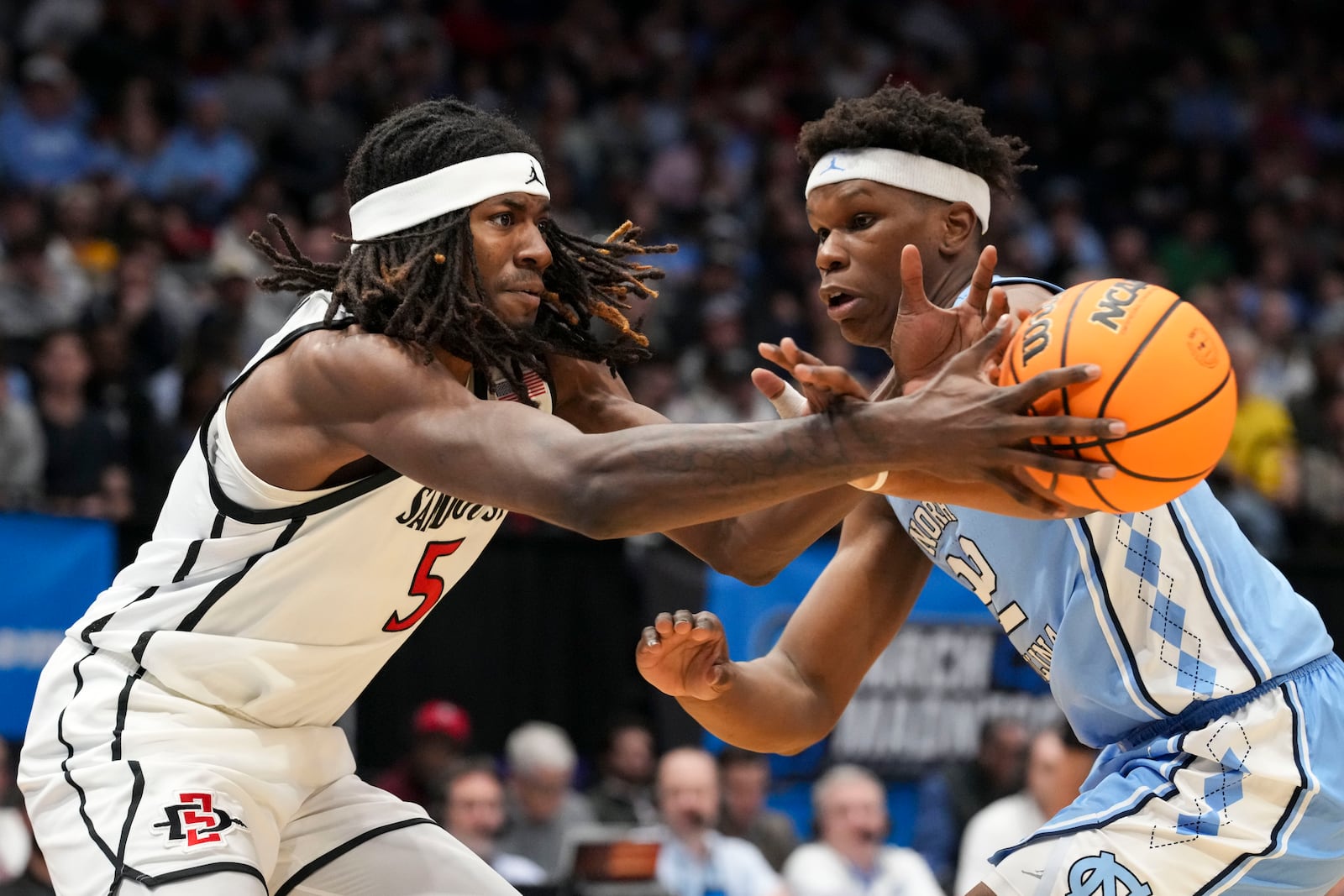 San Diego State forward Pharaoh Compton (5) passes against North Carolina forward Ven-Allen Lubin (22) during the first half of a First Four college basketball game in the NCAA Tournament, Tuesday, March 18, 2025, in Dayton, Ohio. (AP Photo/Jeff Dean)