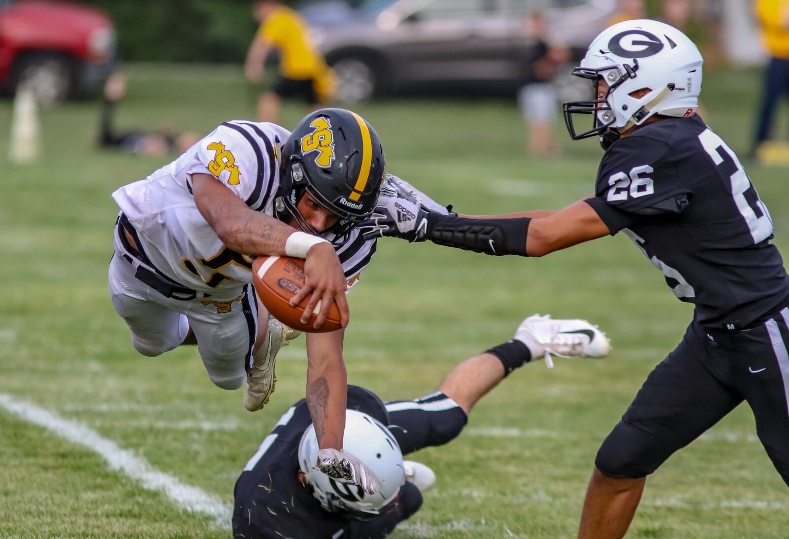 Shawnee High School senior quarterback Robie Glass leaps for a first down as he’s pushed out of bounds by Greenon freshman Zach Stevens during their game on Friday night at Greenon Stadium. The Knights won 56-39. CONTRIBUTED PHOTO BY MICHAEL COOPER