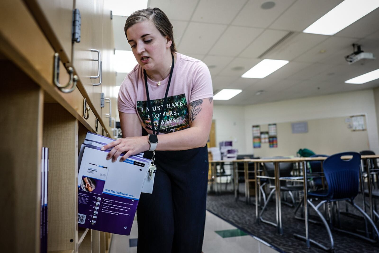 Amy Conrad, a first-year teacher for Dayton Public Schools, stacks books onto shelves Thursday, Aug. 10 in her classroom at E.J. Brown Middle School in preparation for the first day of school Monday. JIM NOELKER/STAFF