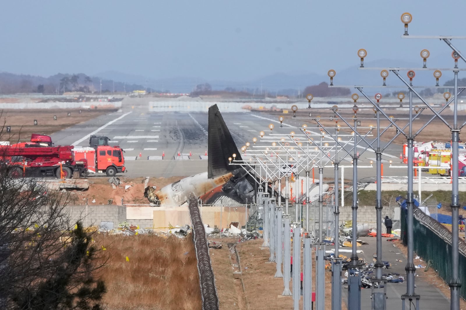 The wreckage of a Boeing 737-800 plane operated by South Korean budget airline Jeju Air lies at Muan International Airport in Muan, South Korea, Tuesday, Dec. 31, 2024. (AP Photo/Ahn Young-joon)