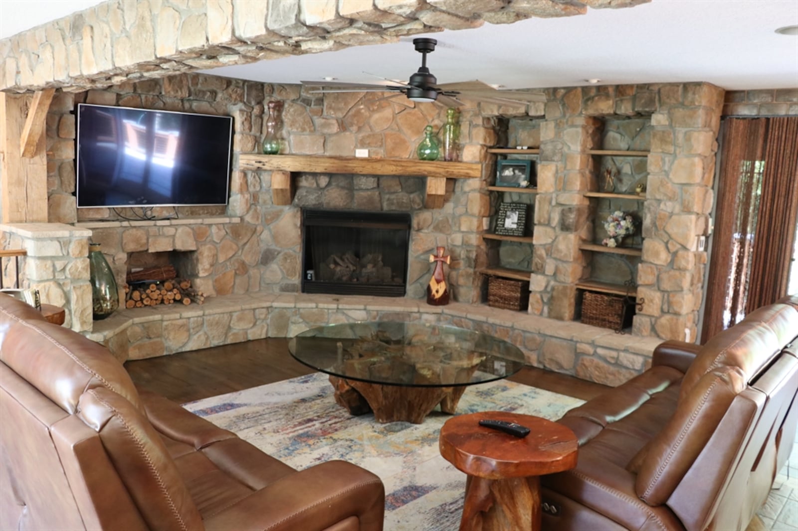 A curved stone wall accents the living room, which features a gas fireplace.