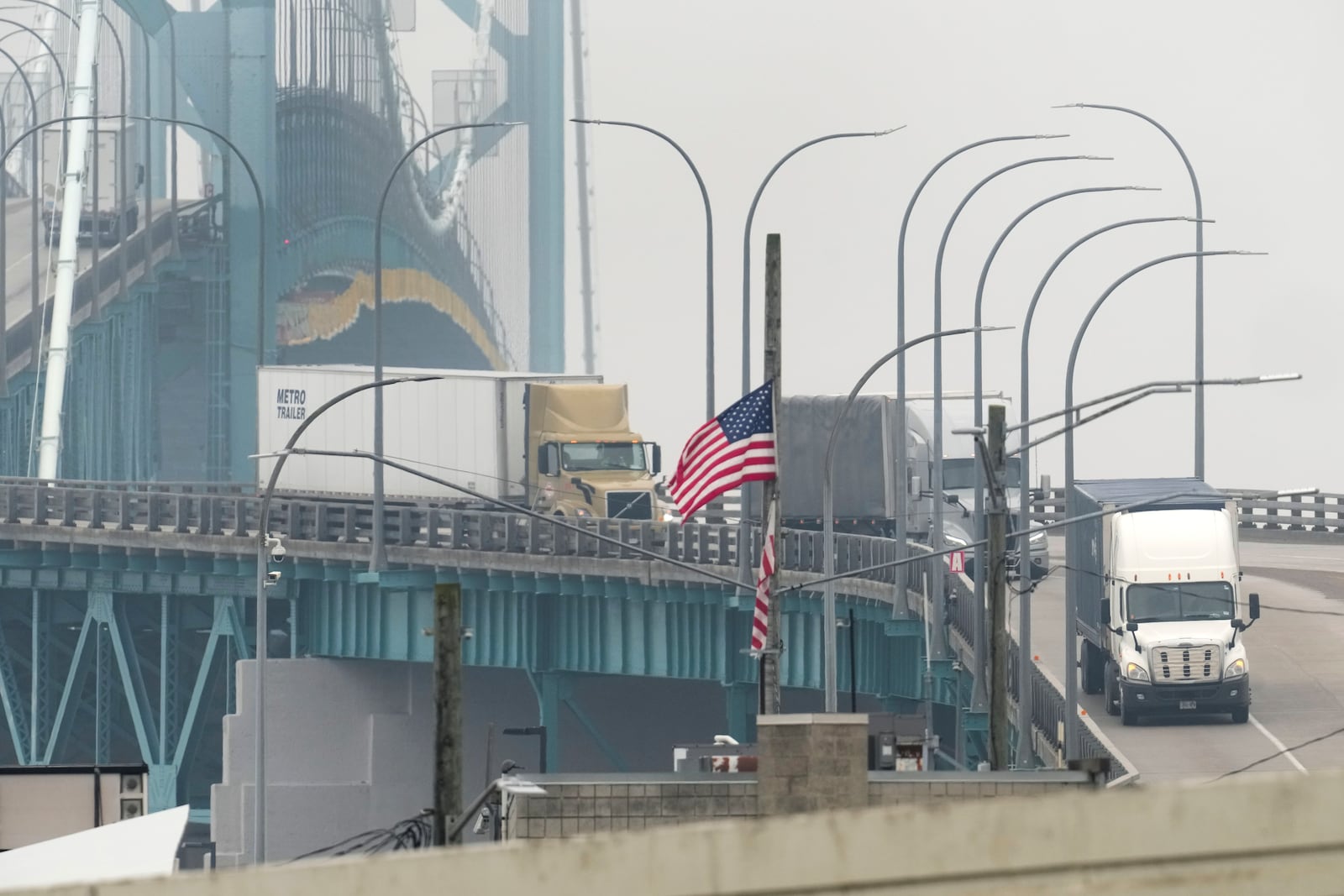 Trucks enter into the United States from Ontario, Canada across the Ambassador Bridge, Monday, Feb. 3, 2025, in Detroit. (AP Photo/Paul Sancya)