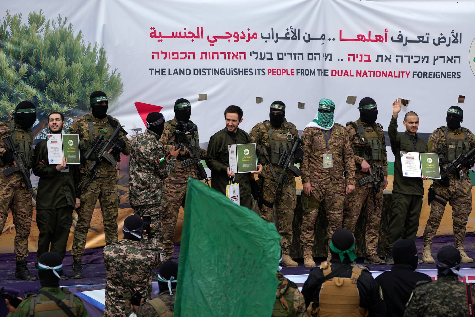 Israeli hostages Eliya Cohen, left, Omer Shem Tov and Omer Wenkert are escorted by Hamas fighters before being handed over to the Red Cross in Nuseirat, central Gaza Strip, Saturday, Feb. 22, 2025. (AP Photo/Abdel Kareem Hana)