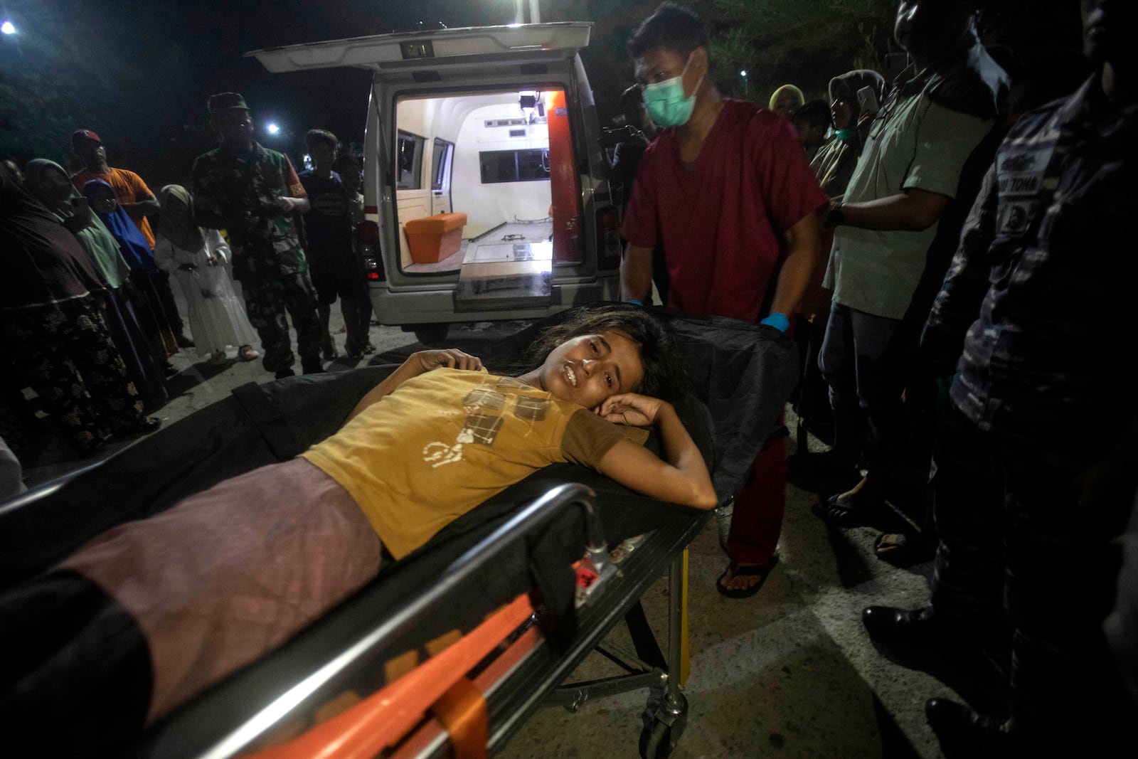 A young girl who was evacuated from a boat carrying Rohingya Muslims lies on a stretcher as she is taken to a local hospital to check on her medical condition in Labuhan Haji, Aceh province, Indonesia, Tuesday, Oct. 22, 2024. (AP Photo/Binsar Bakkara)