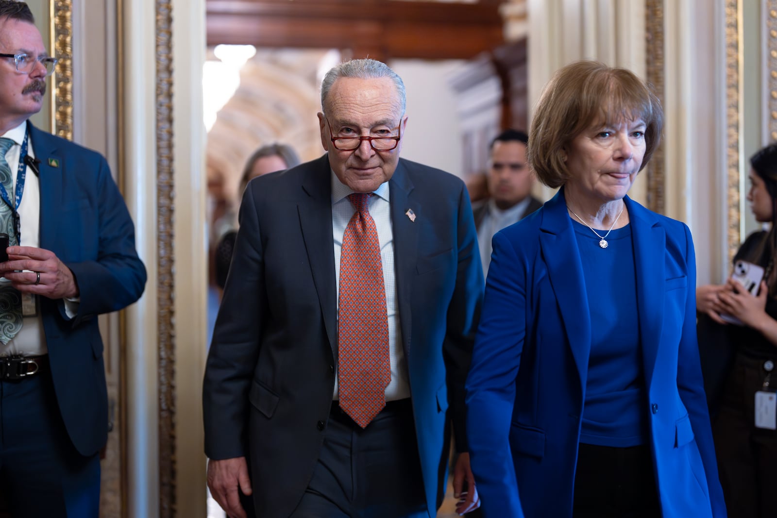 Senate Minority Leader Chuck Schumer, D-N.Y., left, walks with Sen. Tina Smith, D-Minn., as Senate Democrats gather behind closed doors to mount a last-ditch protest over a Republican-led spending bill that already passed the House, at the Capitol in Washington, Thursday, March 13, 2025. (AP Photo/J. Scott Applewhite)